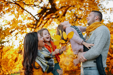 A portrait of young family with two small children in autumn nature at sunset.の写真素材