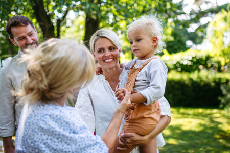 Smiling senior woman with grandchild and daughter at family gathering.