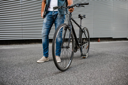 Man riding bike to work in city with helmet and backpackの写真素材