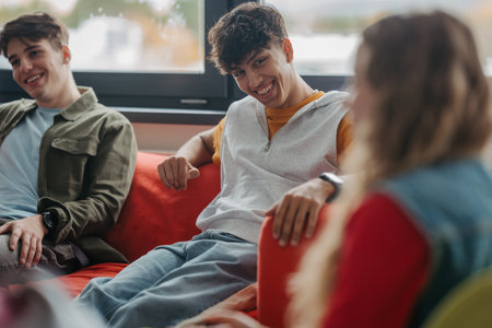 Classmates relaxing and talking in high school lounge.の写真素材