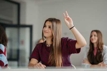 Girl student raising a hand to answear in school.の写真素材