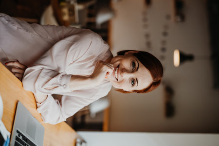 A portrait of woman working remotely from coffee shop, using laptop.の写真素材