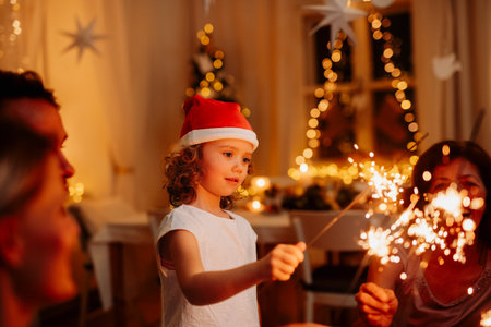 Grandfather and granddaughter holding sparklers during Christmas celebration.の写真素材