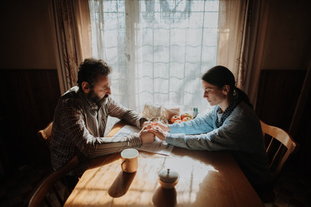 Portrait of poor mature couple sitting at table, fearing the future.の写真素材