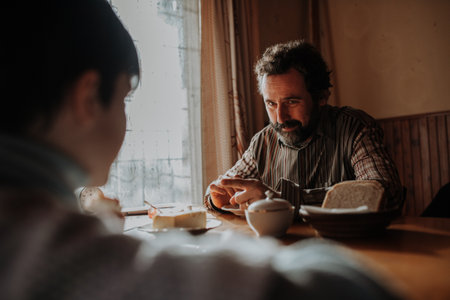 Poor father looking at daughter with love. Family breakfast.の写真素材