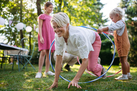 Family enjoying outdoor summer gathering with playful activities.の写真素材