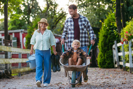 Father pushing toddler boy in wheelbarrow.の写真素材