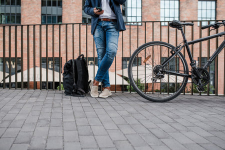 City commuter with bike, reading text message on phone.の写真素材