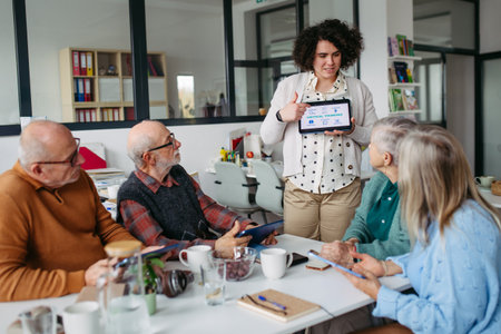 Group of senior people learning digital skills with tutor help.の写真素材