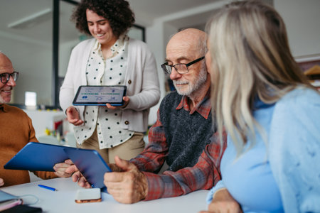 Group of senior people learning digital skills with tutor help.の写真素材