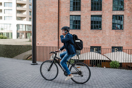 City commuter riding bike to office, wearing backpack and helmet.の写真素材