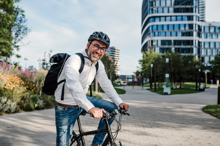 City commuter riding bike to office, wearing backpack and helmet.の写真素材