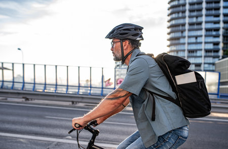 Male cyclist riding bike down the street.の写真素材