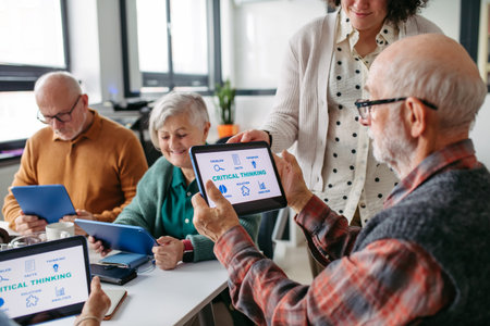 Volunteer teaching seniors how to recognize fake news on digital tablet.の写真素材