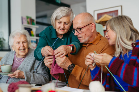 Group of senior people learning knitting together with caregiver tutor in a community center.の写真素材
