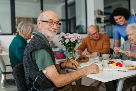 Group of seniors having lunch in community center cafeteria.の写真素材
