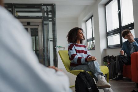 Classmates relaxing and talking in high school lounge.の写真素材