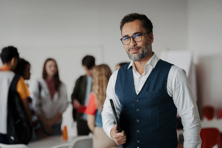 Teacher holding a tablet in modern high school classroom.の写真素材