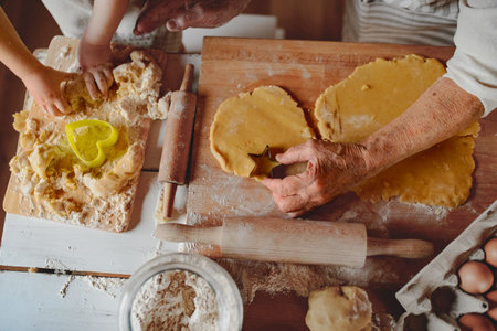 Hands of old woman and kid preparing homemade cookies.の写真素材