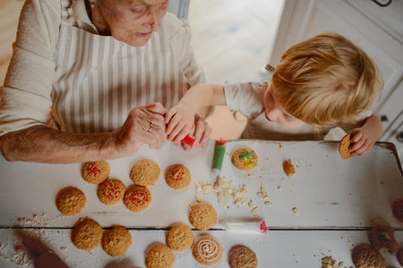 Christmas baking and decorating of cookies with grandma and little kid.の写真素材