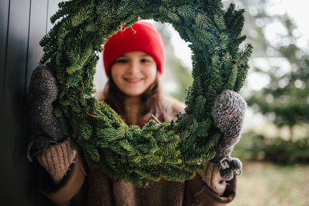 Girl holding a handmade Christmas wreath.の写真素材
