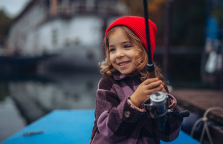 Child enjoying fishing outdoors during cold season.