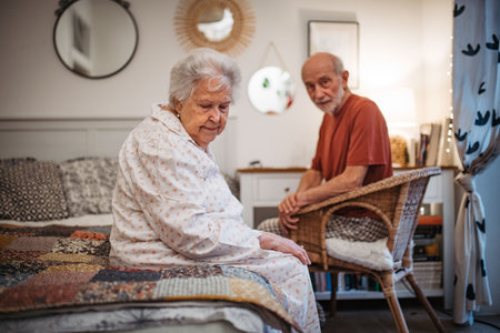 Elderly spouses sharing quiet moment before sleep.