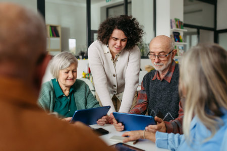 Volunteer teaching seniors how to recognize fake news on digital tablet.の写真素材