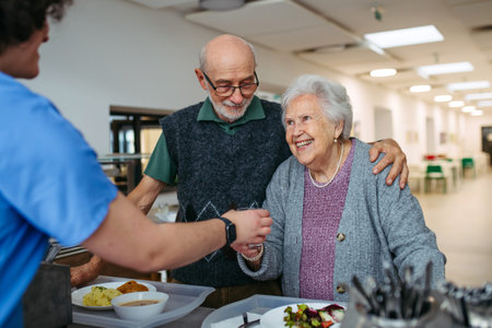 Elderly couple having lunch in community center cafeteria.の写真素材