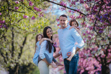 Young family standing outside in spring nature.