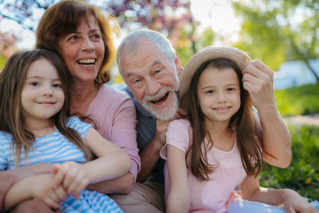 Grandparents spending time with granddaughters in park.の写真素材
