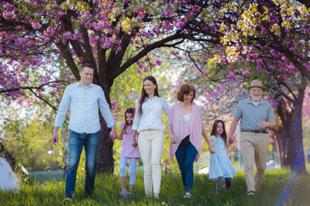 Three generation family on walk in spring nature.