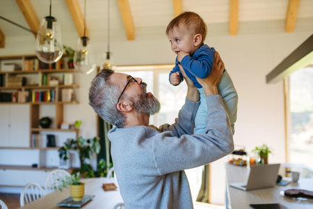 Dad holding his little toddler son in arms.