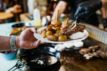 Serving hot meal on plate at buffet self service dining.の写真素材