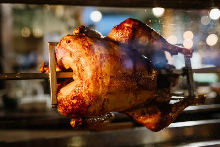 Rotisserie chicken cooking inside oven.