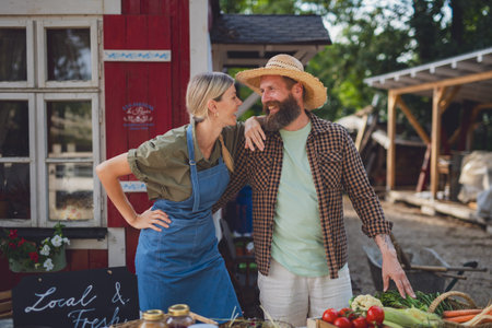 Couple selling fresh organic produce at local farmers market.の写真素材
