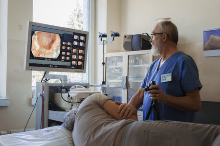 Doctor looking at monitior during gastroscopy procedure, examining upper digestive tract.