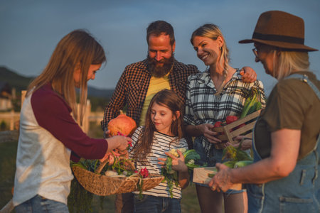 Farmers carrying basket with harvest and looking at homegrown vegetables outdoors at community garden.