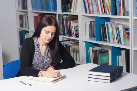 Young beautiful female student studying in libraryのeditorial素材