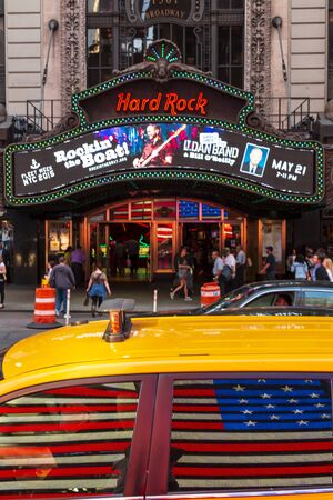 New York, USA - May 19 2015: American flag reflecting at Yellow New York taxi in front of the Hard Rock Cafe in Times Square, New York City, United States of America, North Americaのeditorial素材
