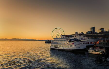 Seattle, USA - September 28 2017: Two Sightseeing cruise ships standing at the dock during the sunset over Elliott Bay in Seattle, Washington, USA.のeditorial素材