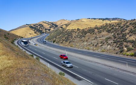 YOSEMITE, USA - JUNE 3, 2018: Driving through the golden hills of California the San Luis Reservoir State Recreation area sign and dam on the right side of the roadのeditorial素材