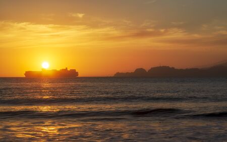 Sun sets near thr Golden Gate Bridge, Baker Beach, San Francisco, California, USAの写真素材