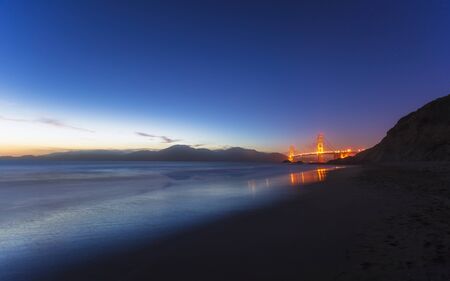 Soft flowing water reflects the beautiful Golden Gate Bridgefrom Baker beach, San Francisco, California, United States of America, North Americaの写真素材