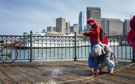 San Francisco, USA - June 9 2018: Fisherman on Pier 7 and San Francisco skyline, California, United States of America, North Americaのeditorial素材