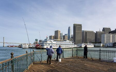 San Francisco, USA - June 9 2018: Fisherman on Pier 7 and San Francisco skyline, California, United States of America, North Americaのeditorial素材