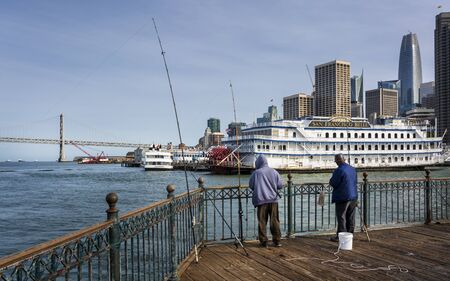 San Francisco, USA - June 9 2018: Fisherman on Pier 7 and San Francisco skyline, California, United States of America, North Americaのeditorial素材