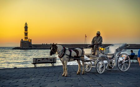 Crete, Greece - April 23 2018: Sunset over The Venetian era harbour and lighthouse at the Mediterranean port of Chania, Crete, Greek Islands, Greece, Europeのeditorial素材