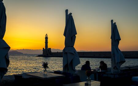Crete, Greece - April 23 2018: Sunset over The Venetian era harbour and lighthouse at the Mediterranean port of Chania, Crete, Greek Islands, Greece, Europeのeditorial素材