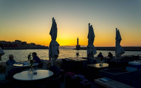 Crete, Greece - April 23 2018: Sunset over The Venetian era harbour and lighthouse at the Mediterranean port of Chania, Crete, Greek Islands, Greece, Europeのeditorial素材